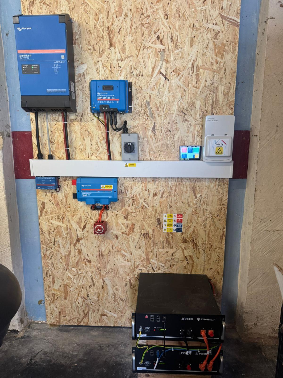 Installed Victron inverter, solar charge controller and battery equipment for an off-grid system