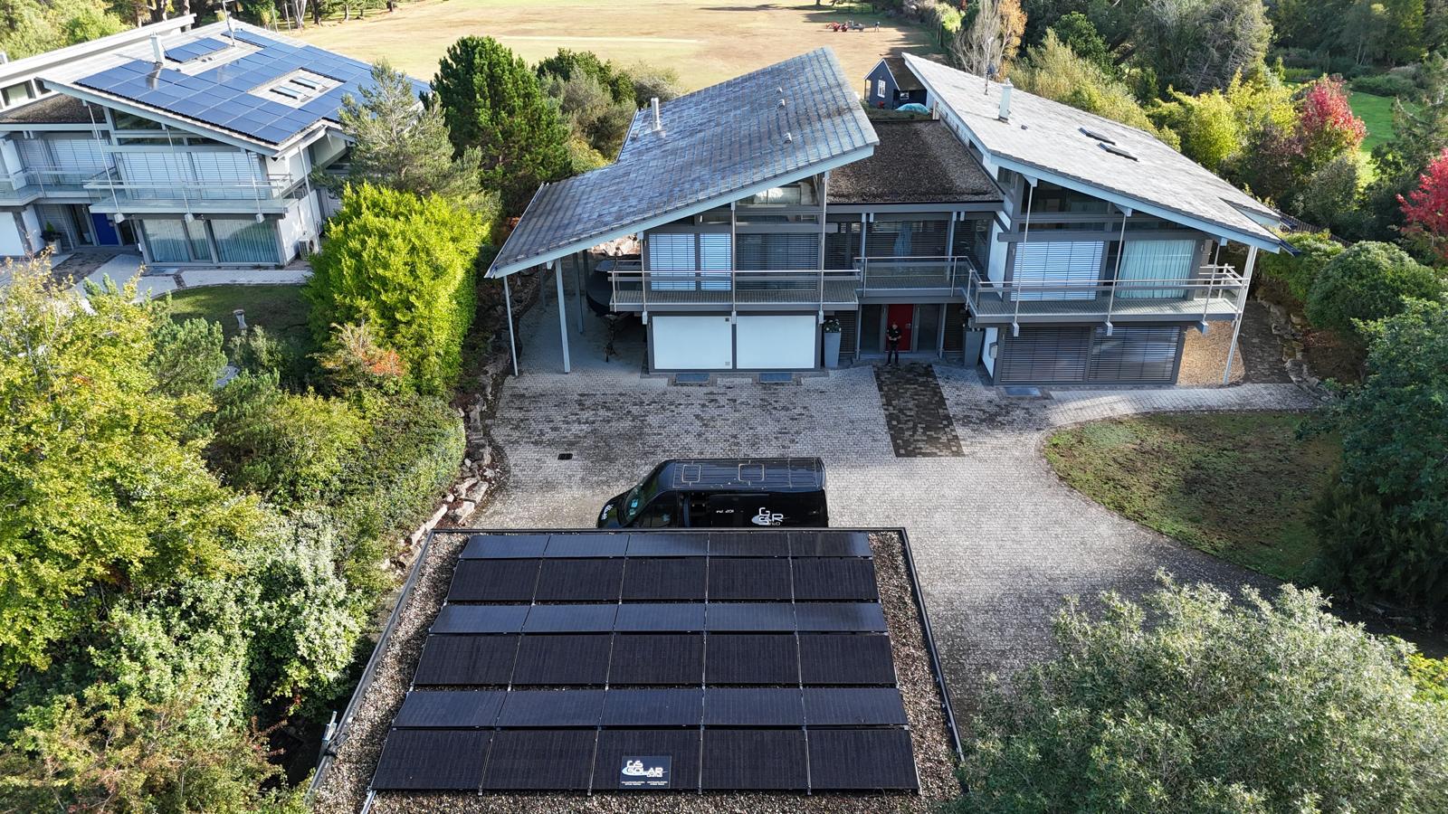 Aerial view of a large home with a GS Solar flat roof solar array