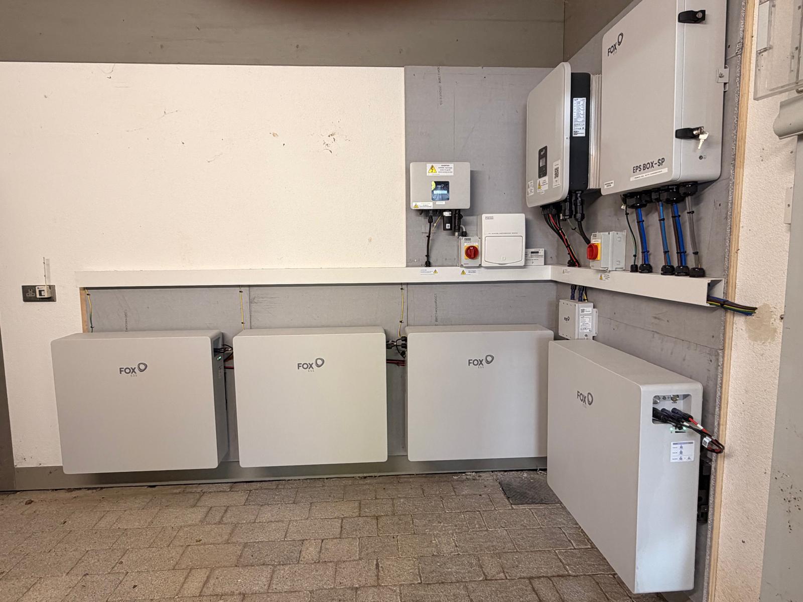 Multiple Fox ESS batteries and inverters on a plant room wall