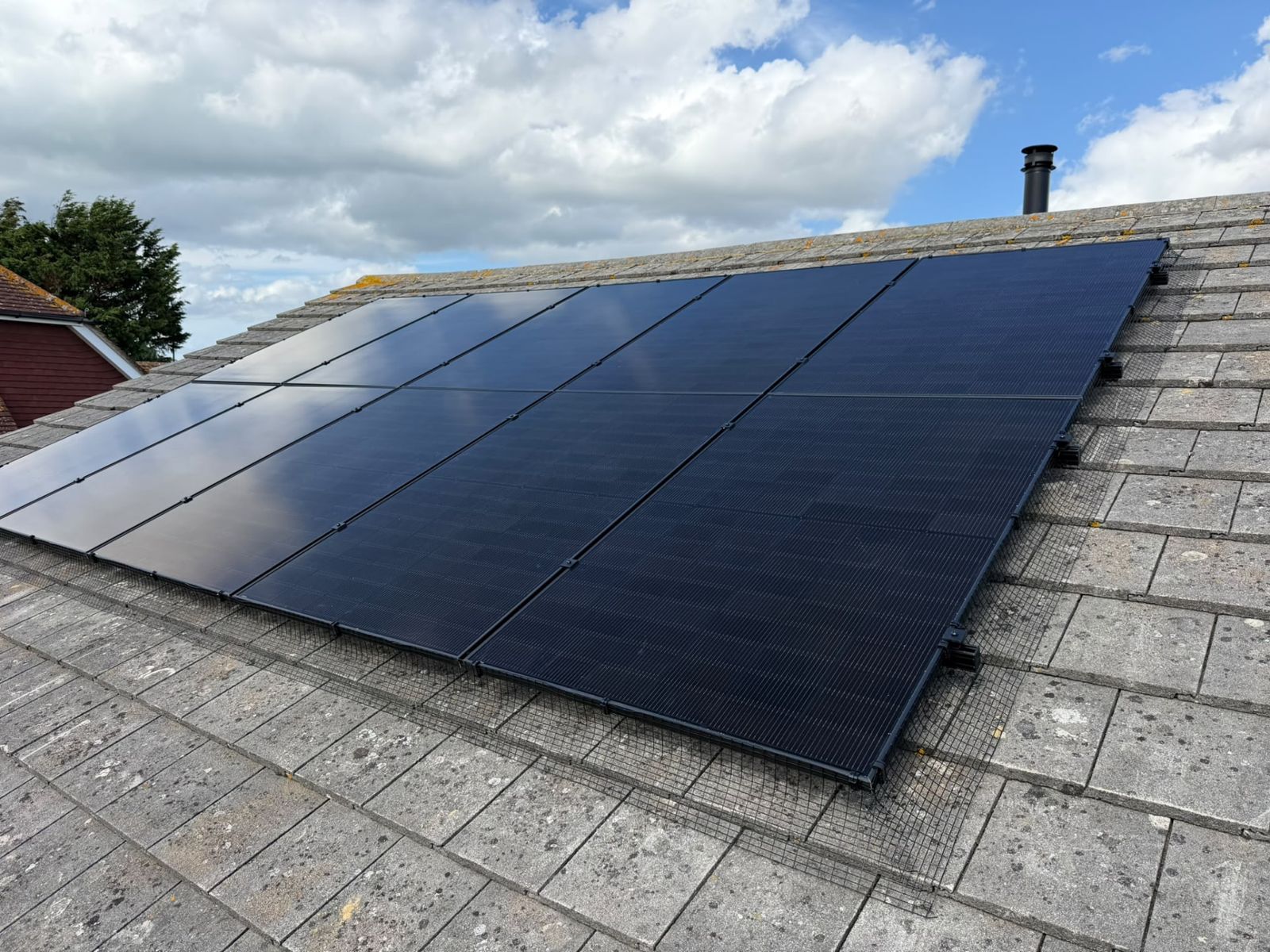 Close-up of finished black solar panels on a concrete tile roof