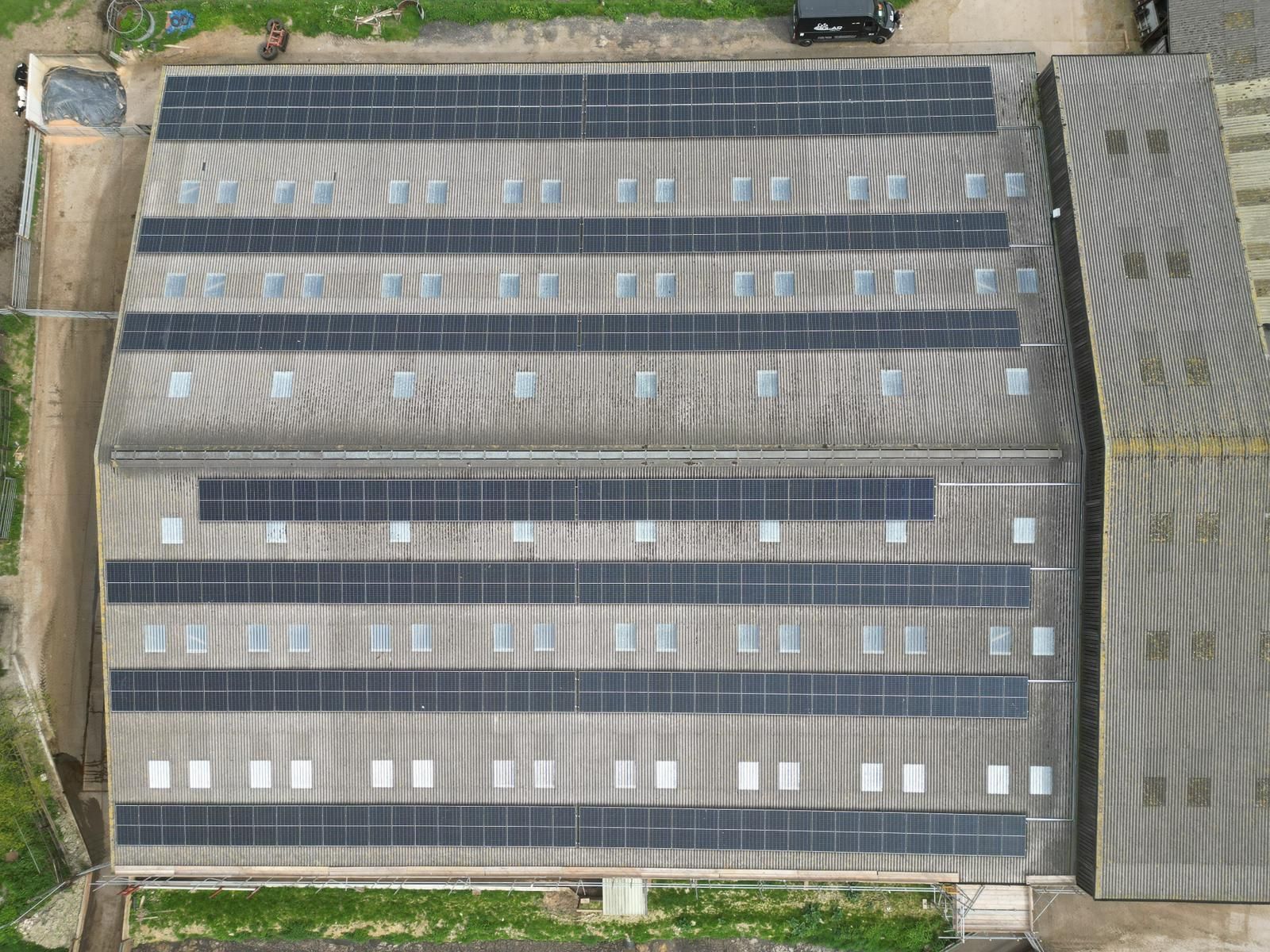 Aerial view of a large commercial roof solar installation